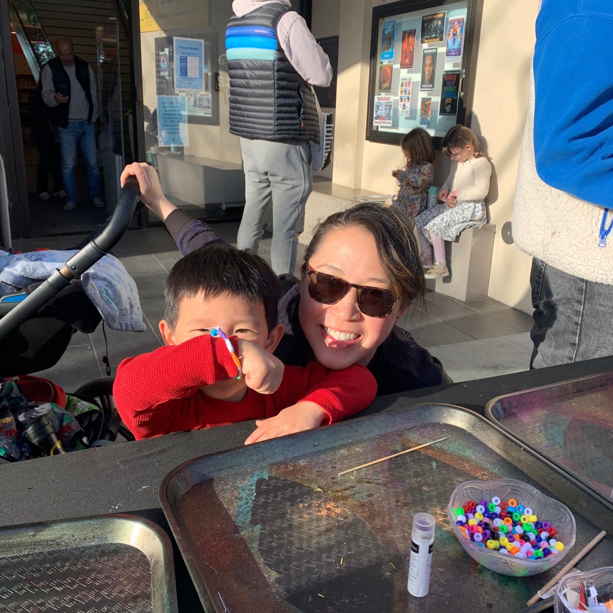 a person standing in front of art supplies with child