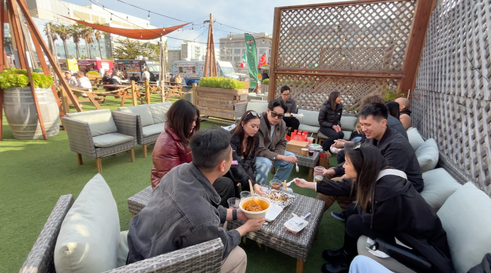 a group of people sitting at a picnic table