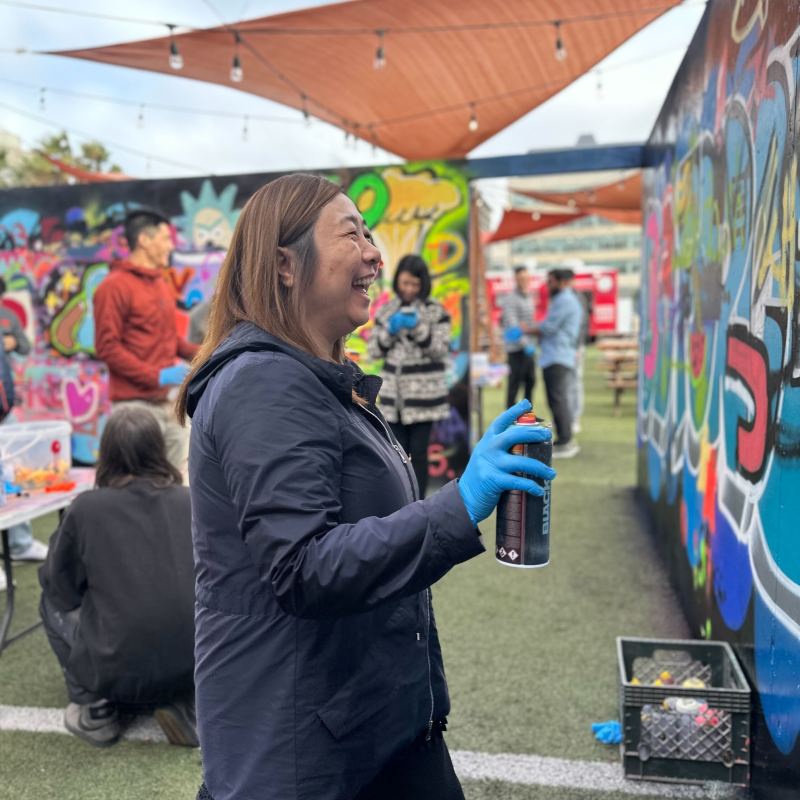a group of people standing in front of a colorful umbrella