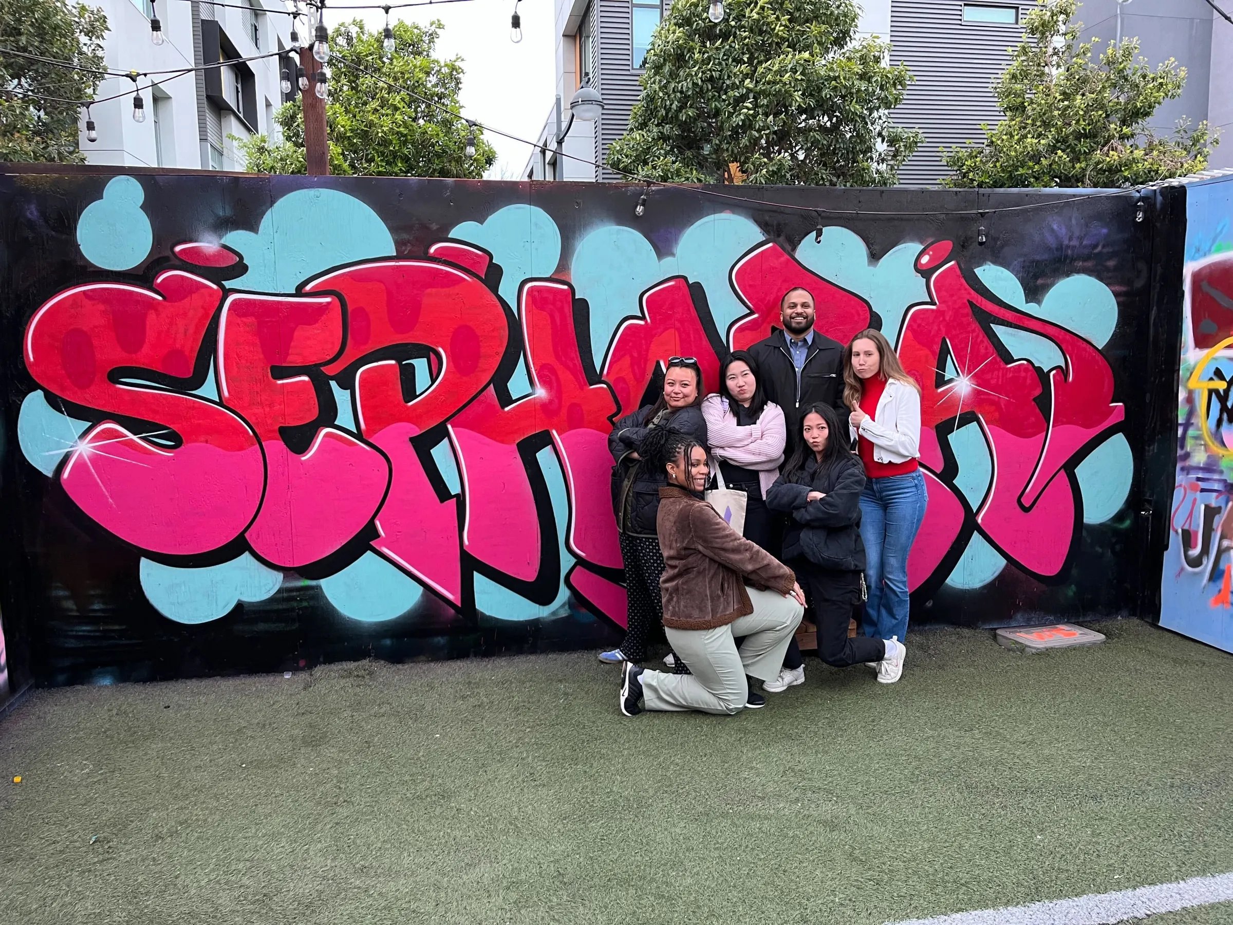 a group of people standing in front of a graffiti wall