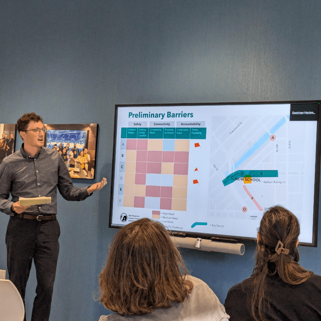 a person standing in front of a group of people in a room presenting at a CAC meeting