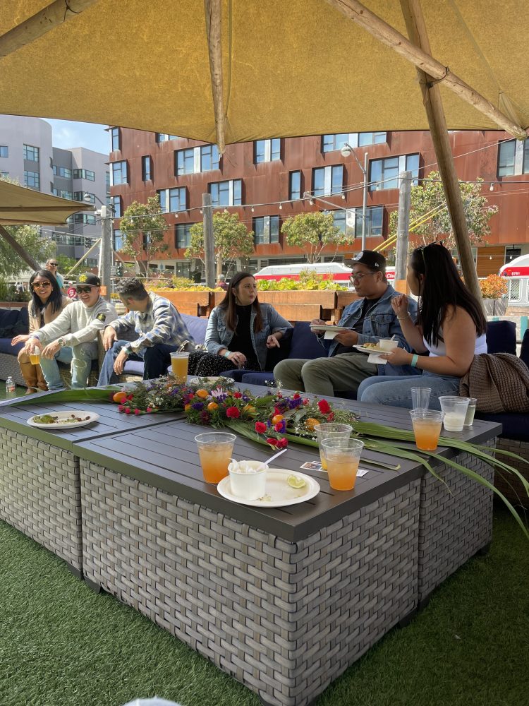a group of people sitting at a table in front of a building